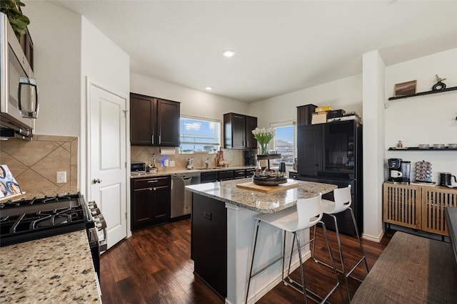7304 Fall Ray Dr, Del Valle, TX 78617 - kitchen featuring stainless steel appliances, a breakfast bar, backsplash, a center island, and recessed lighting