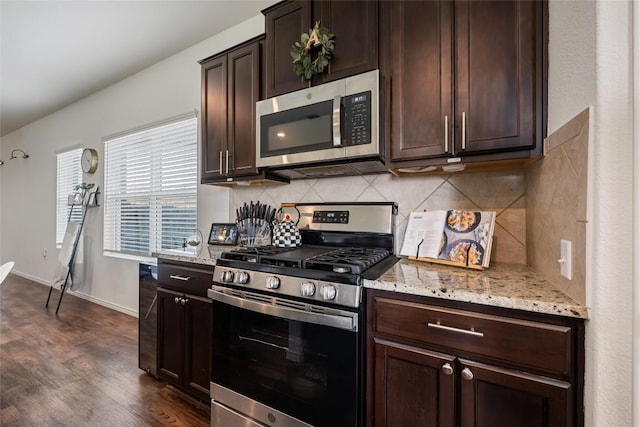7304 Fall Ray Dr, Del Valle, TX 78617 - kitchen with stainless steel appliances, light stone counters, backsplash, and dark brown cabinetry