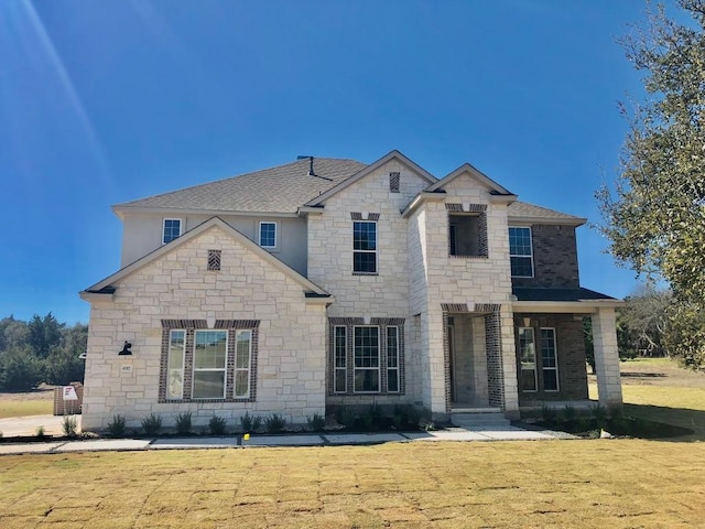 657 Prairie Clover Dr, Dripping Springs, TX 78620 - french country inspired facade featuring stone siding, a front yard, and roof with shingles