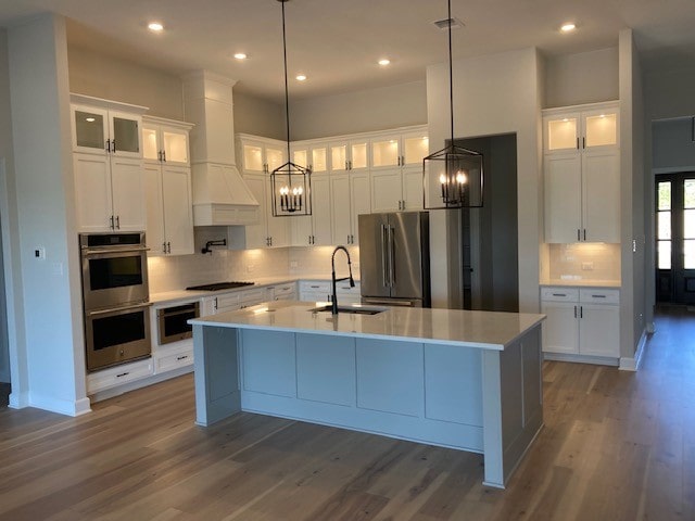 120 Prairie Clover Dr, Dripping Springs, TX 78620 - kitchen with appliances with stainless steel finishes, custom exhaust hood, a chandelier, wood finished floors, and recessed lighting