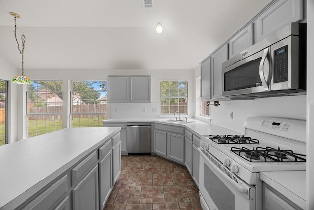 706 Cornell Dr, Pflugerville, TX 78660 - kitchen with stainless steel appliances, gray cabinetry, light countertops, and hanging light fixtures