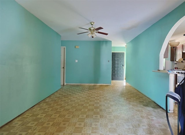 6110 Calmar Cv, Austin, TX 78721 - empty room with arched walkways, a ceiling fan, and tile patterned floors