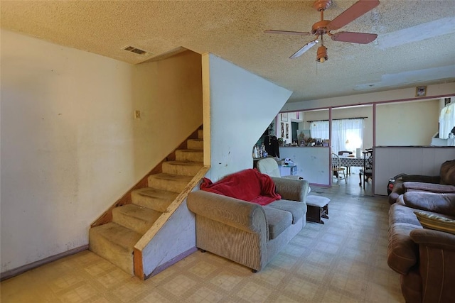 6110 Calmar Cv, Austin, TX 78721 - living area featuring a textured ceiling, tile patterned floors, stairs, and a ceiling fan