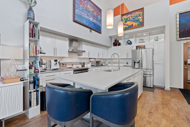1600 Barton Springs Rd Unit 5406, Austin, TX 78704 - kitchen with stainless steel appliances, wall chimney range hood, a high ceiling, light countertops, and open shelves