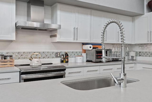 1600 Barton Springs Rd Unit 5406, Austin, TX 78704 - kitchen featuring wall chimney range hood, electric stove, light countertops, and white cabinets
