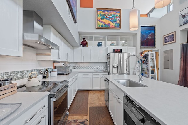 1600 Barton Springs Rd Unit 5406, Austin, TX 78704 - kitchen with appliances with stainless steel finishes, wall chimney exhaust hood, light countertops, a towering ceiling, and white cabinets