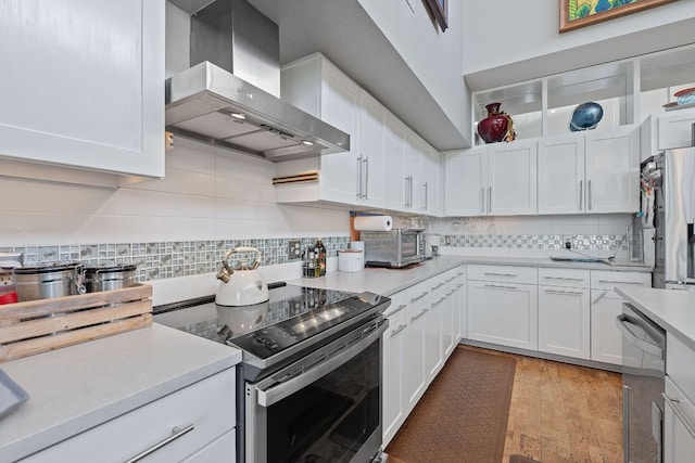 1600 Barton Springs Rd Unit 5406, Austin, TX 78704 - kitchen featuring wall chimney range hood, stainless steel appliances, light countertops, and white cabinets