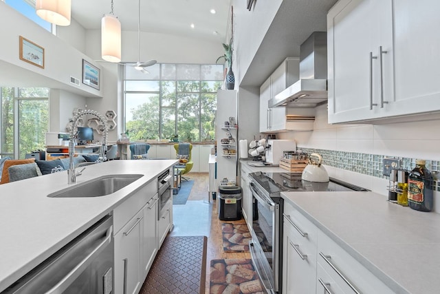 1600 Barton Springs Rd Unit 5406, Austin, TX 78704 - kitchen with appliances with stainless steel finishes, wall chimney exhaust hood, light countertops, tasteful backsplash, and white cabinetry