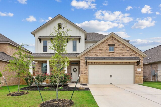 627 Cold River Run, Kyle, TX 78640 - view of front of property featuring board and batten siding, concrete driveway, brick siding, a front yard, and an attached garage