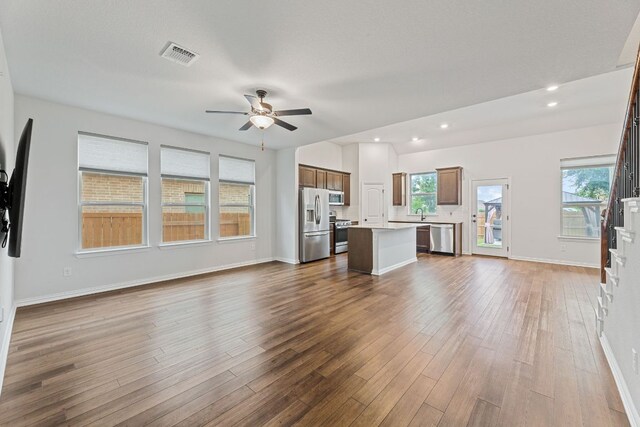 627 Cold River Run, Kyle, TX 78640 - unfurnished living room with a ceiling fan, dark wood-style floors, and recessed lighting