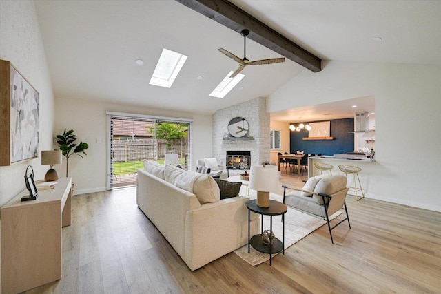 7906 Swindon Ln, Austin, TX 78745 - living area with a stone fireplace, beamed ceiling, light wood-style floors, a chandelier, and a skylight