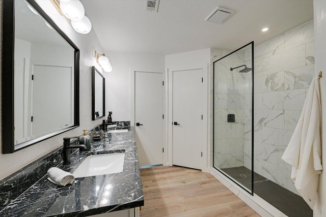 7906 Swindon Ln, Austin, TX 78745 - bathroom featuring a marble finish shower, double vanity, wood finished floors, and recessed lighting