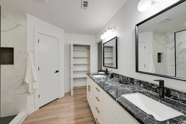 7906 Swindon Ln, Austin, TX 78745 - full bath with a marble finish shower, double vanity, and wood finished floors