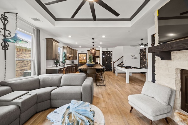 614 W Martingale St W, Georgetown, TX 78633 - living room with crown molding, a ceiling fan, a tray ceiling, stairs, and light wood-style floors
