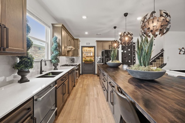 614 W Martingale St W, Georgetown, TX 78633 - kitchen with stainless steel appliances, wooden counters, light wood-type flooring, tasteful backsplash, and under cabinet range hood