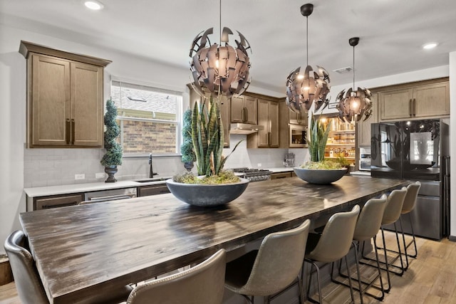 614 W Martingale St W, Georgetown, TX 78633 - kitchen featuring freestanding refrigerator, a chandelier, decorative backsplash, light wood-style floors, and decorative light fixtures