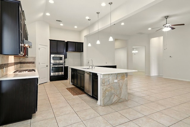 2516 Silver Fern Ln, Pflugerville, TX 78660 - kitchen featuring stainless steel appliances, light tile patterned flooring, decorative backsplash, dark cabinetry, and recessed lighting