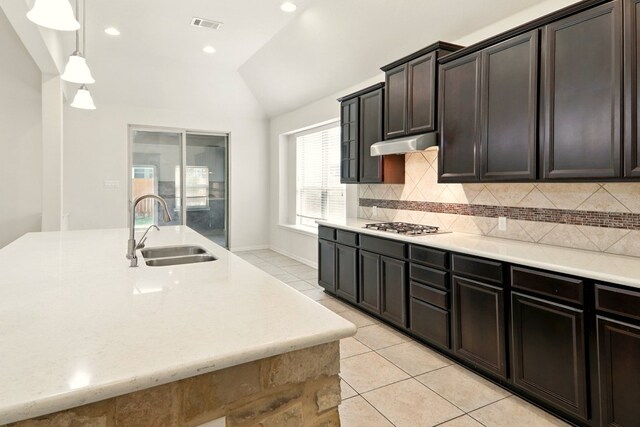 2516 Silver Fern Ln, Pflugerville, TX 78660 - kitchen with vaulted ceiling, light tile patterned floors, decorative backsplash, hanging light fixtures, and recessed lighting