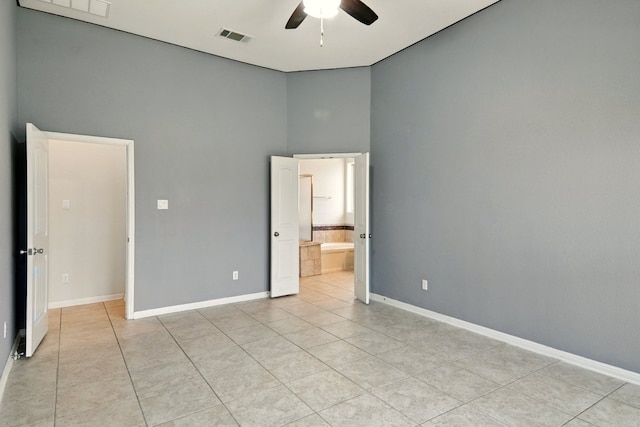 2516 Silver Fern Ln, Pflugerville, TX 78660 - unfurnished bedroom featuring light tile patterned floors, a high ceiling, connected bathroom, and ceiling fan