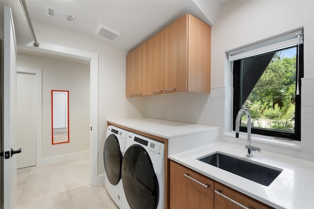 419 Brady Ln, Austin, TX 78746 - laundry area featuring cabinet space, washing machine and clothes dryer, and light tile patterned flooring