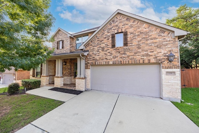 128 Lady Bird Ln, Georgetown, TX 78628 - view of front facade with stone siding, driveway, a garage, and brick siding