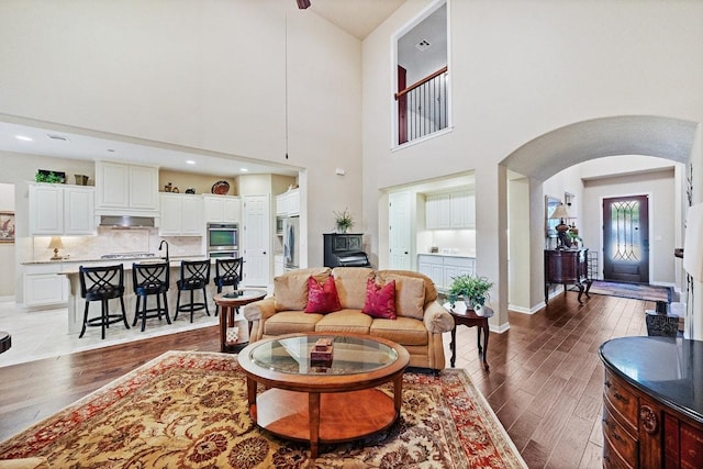 128 Lady Bird Ln, Georgetown, TX 78628 - living room with arched walkways, wood finished floors, and a towering ceiling