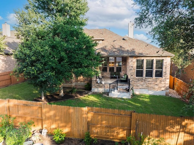 128 Lady Bird Ln, Georgetown, TX 78628 - rear view of property featuring a chimney, a fenced backyard, brick siding, and a shingled roof