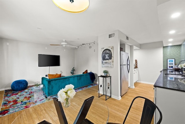 living room featuring light wood-style flooring, a ceiling fan, and recessed lighting