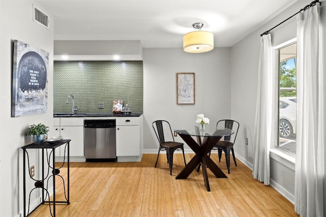 dining room featuring light wood finished floors and wet bar