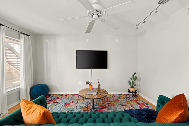 living area with a ceiling fan and track lighting