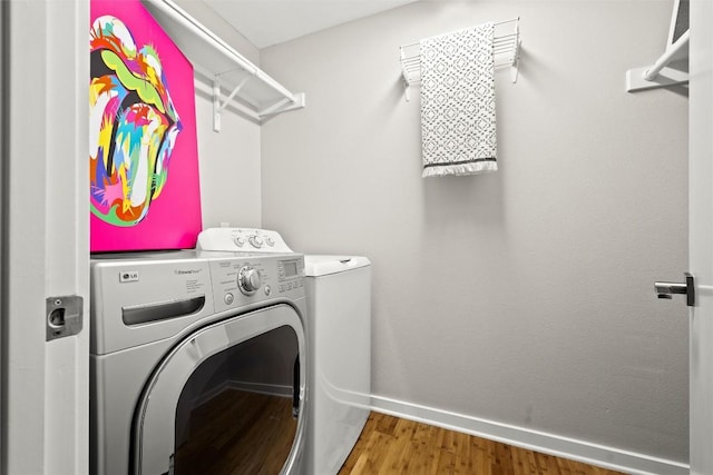 washroom with washing machine and clothes dryer and wood finished floors