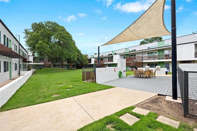 view of green lawn featuring a residential view and outdoor dining space