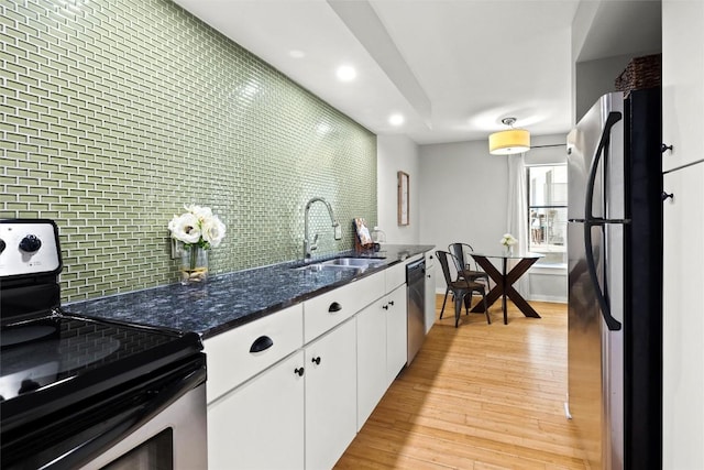 kitchen featuring stainless steel appliances, white cabinets, backsplash, light wood finished floors, and recessed lighting