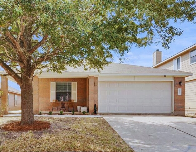 12701 Paloma Blanca Way, Del Valle, TX 78617 - view of front facade with brick siding, an attached garage, and concrete driveway