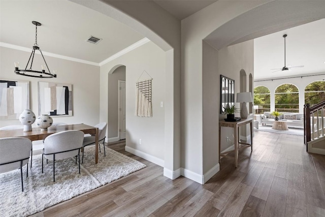 4604 Hibiscus Valley Dr, Austin, TX 78739 - dining area featuring a ceiling fan, wood finished floors, ornamental molding, arched walkways, and a chandelier