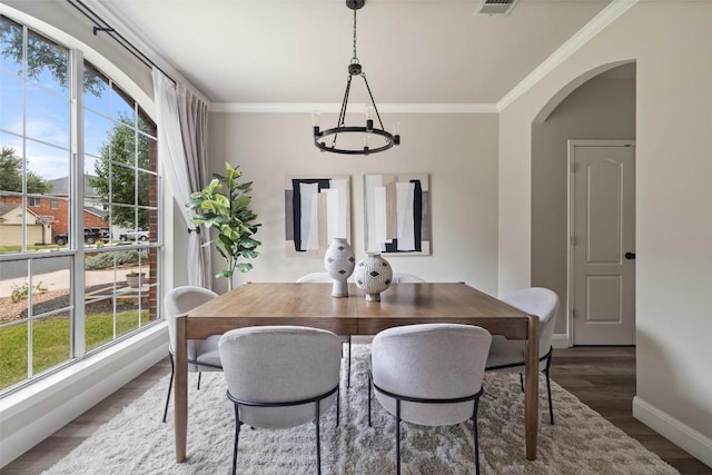 4604 Hibiscus Valley Dr, Austin, TX 78739 - dining room featuring a chandelier, plenty of natural light, arched walkways, wood finished floors, and crown molding