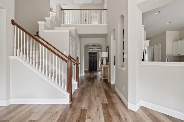 4604 Hibiscus Valley Dr, Austin, TX 78739 - foyer featuring arched walkways, wood finished floors, stairs, and a towering ceiling
