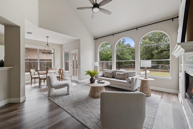 4604 Hibiscus Valley Dr, Austin, TX 78739 - living area featuring a warm lit fireplace, healthy amount of natural light, wood finished floors, and high vaulted ceiling