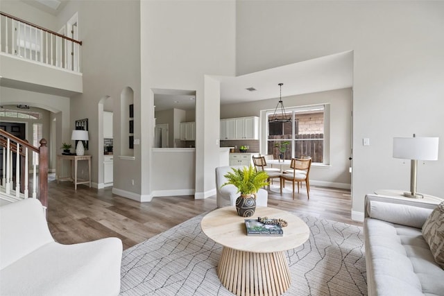 4604 Hibiscus Valley Dr, Austin, TX 78739 - living area featuring light wood-style flooring, a high ceiling, arched walkways, and stairway