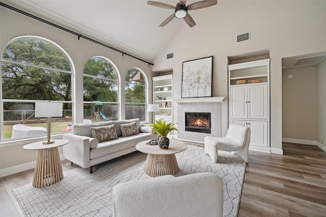 4604 Hibiscus Valley Dr, Austin, TX 78739 - living area featuring a fireplace, wood finished floors, a ceiling fan, high vaulted ceiling, and built in shelves
