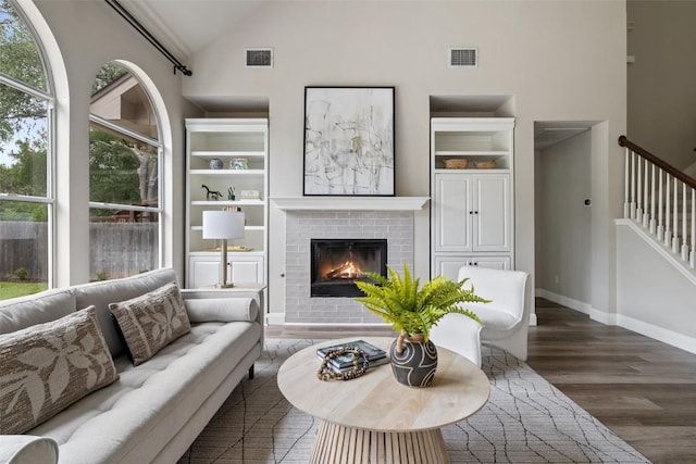 4604 Hibiscus Valley Dr, Austin, TX 78739 - living room with wood finished floors, a brick fireplace, built in shelves, high vaulted ceiling, and stairway