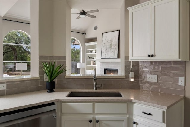 4604 Hibiscus Valley Dr, Austin, TX 78739 - kitchen featuring dishwasher, a ceiling fan, backsplash, a fireplace, and vaulted ceiling