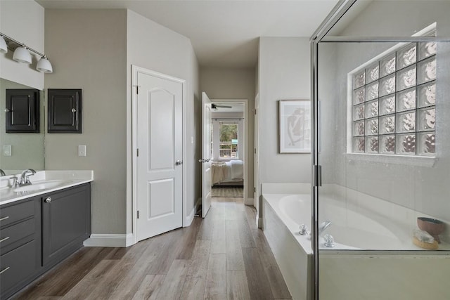 4604 Hibiscus Valley Dr, Austin, TX 78739 - ensuite bathroom featuring a garden tub, vanity, and wood finished floors