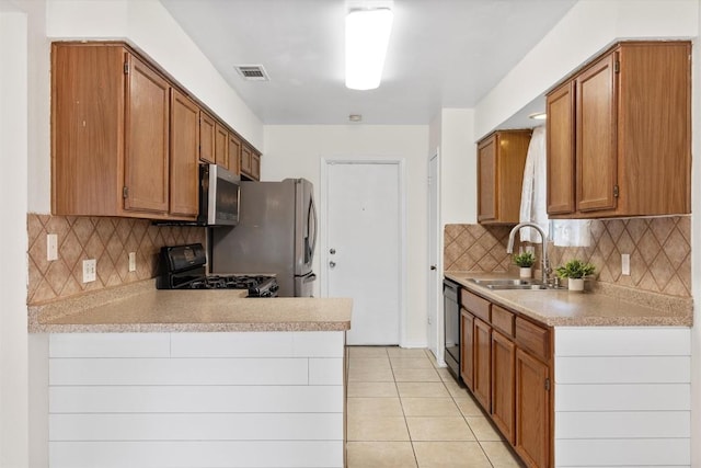 9400 Canus Dr, Austin, TX 78748 - kitchen with appliances with stainless steel finishes, light countertops, a peninsula, light tile patterned flooring, and decorative backsplash