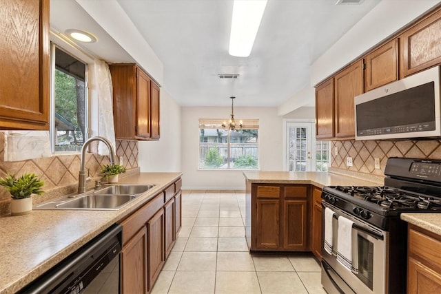 9400 Canus Dr, Austin, TX 78748 - kitchen featuring stainless steel appliances, light tile patterned flooring, and brown cabinetry