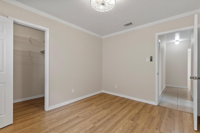 9400 Canus Dr, Austin, TX 78748 - unfurnished bedroom with a spacious closet, light wood-style flooring, ornamental molding, and a closet