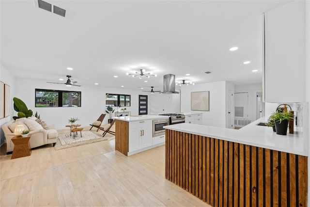 1305 Ridgehaven Dr, Austin, TX 78723 - kitchen with island range hood, appliances with stainless steel finishes, a peninsula, open floor plan, and recessed lighting