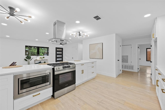 1305 Ridgehaven Dr, Austin, TX 78723 - kitchen featuring stainless steel appliances, a chandelier, island exhaust hood, light countertops, and recessed lighting
