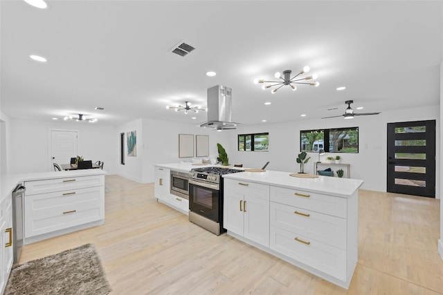 1305 Ridgehaven Dr, Austin, TX 78723 - kitchen with stainless steel appliances, island range hood, a chandelier, recessed lighting, and white cabinetry