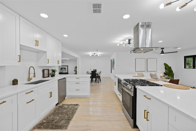 1305 Ridgehaven Dr, Austin, TX 78723 - kitchen featuring stainless steel appliances, island exhaust hood, light countertops, a peninsula, and recessed lighting